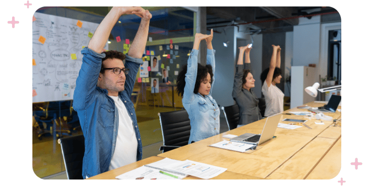 workers stretching at their desks to improve flexibility