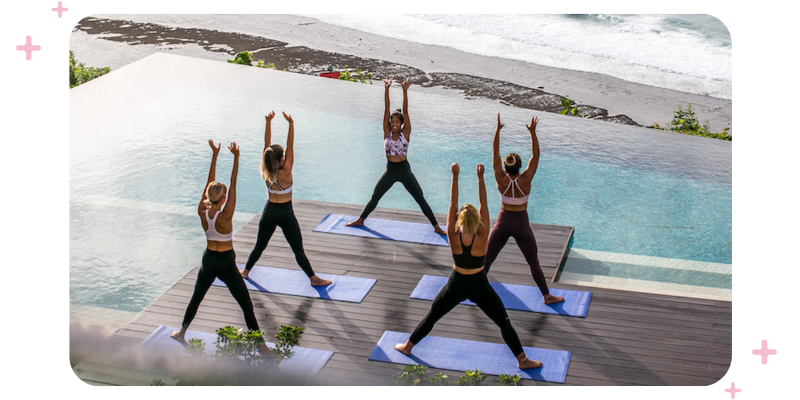 Group of women performing Pilates by the pool