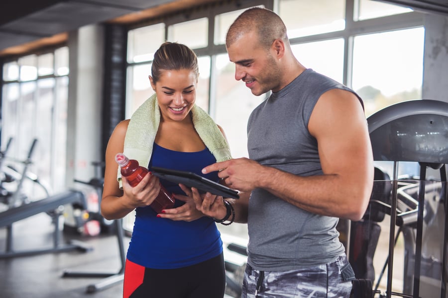 Personal trainer taking his client through her workout plan.