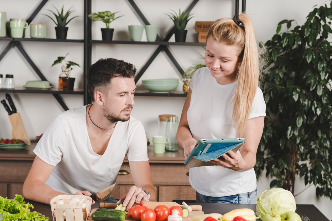 A nutrition coach showing a client how to prepare healthy meals in the kitchen.