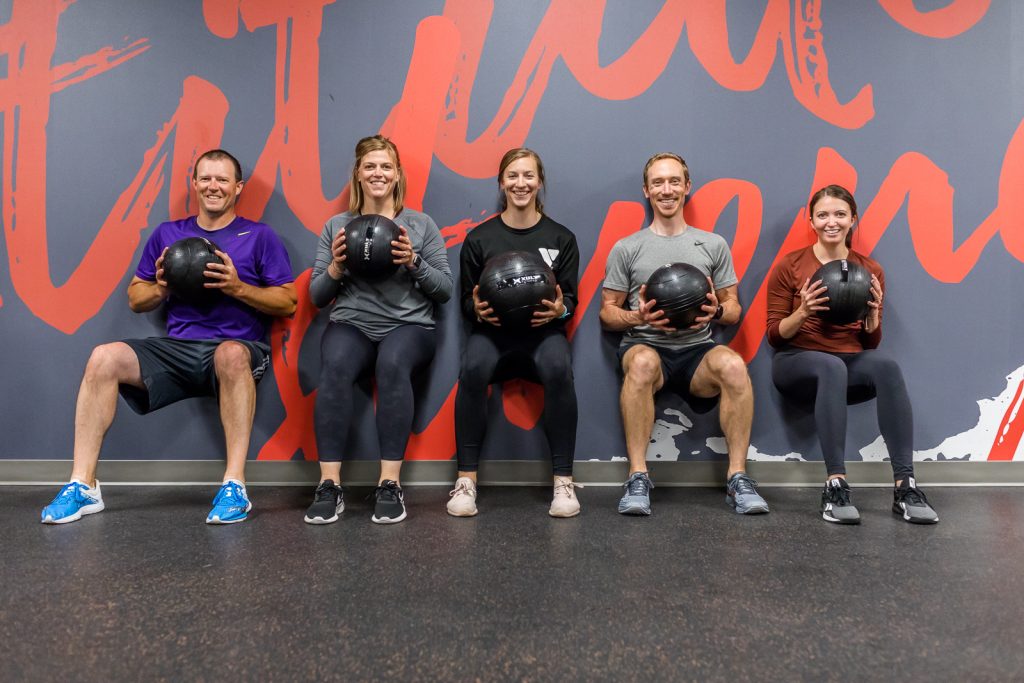 A small workout group exercising using medicine balls.