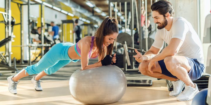 3 personal trainer and customer working out at the gym