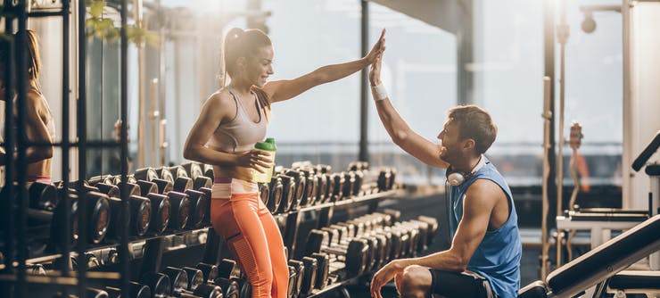 fitness instructor and member celebrating a milestone at the gym