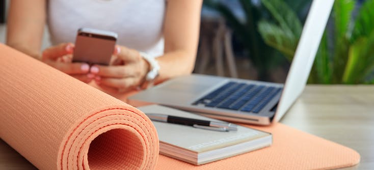 image of a gym owner using social media on their phone and laptop