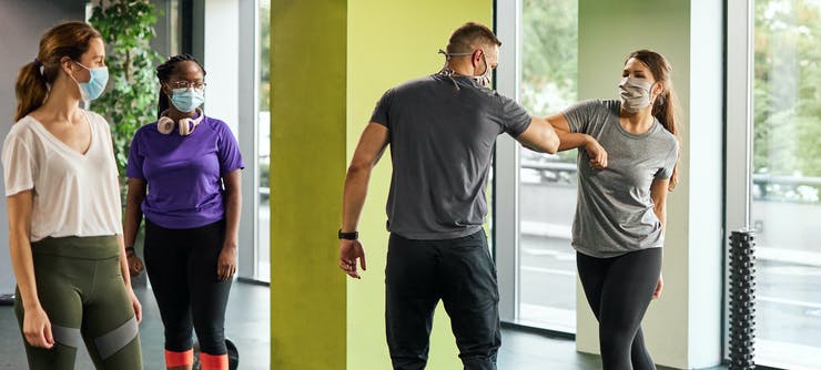 fitness instructor welcoming customers back to class