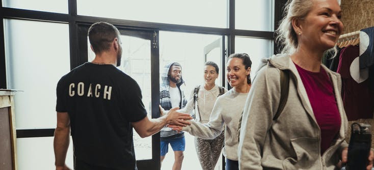 A coach greeting new clients to his gym