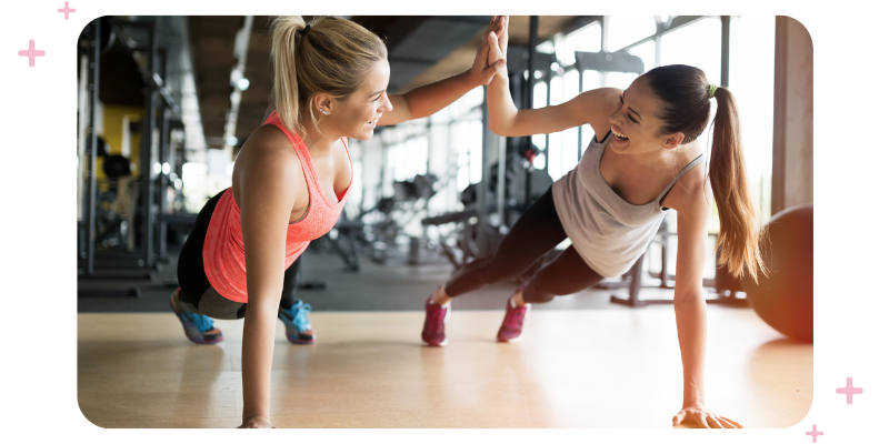 Two women following their workout plan in the gym.