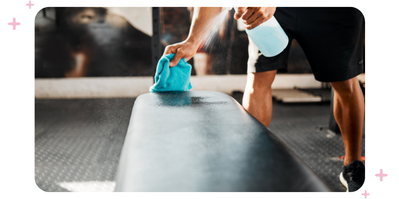 A man cleaning gym equipment.