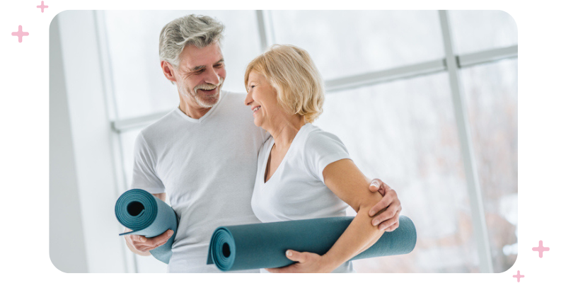 A couple at the studio holding yoga mats.