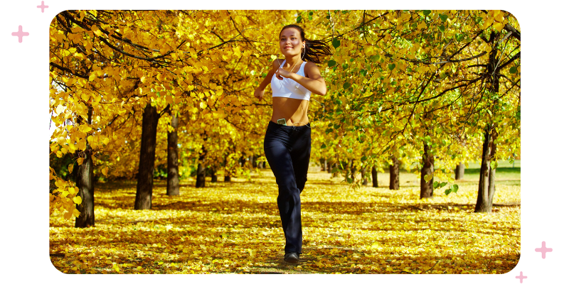 Woman jogging in a park full of yellow-leaved trees