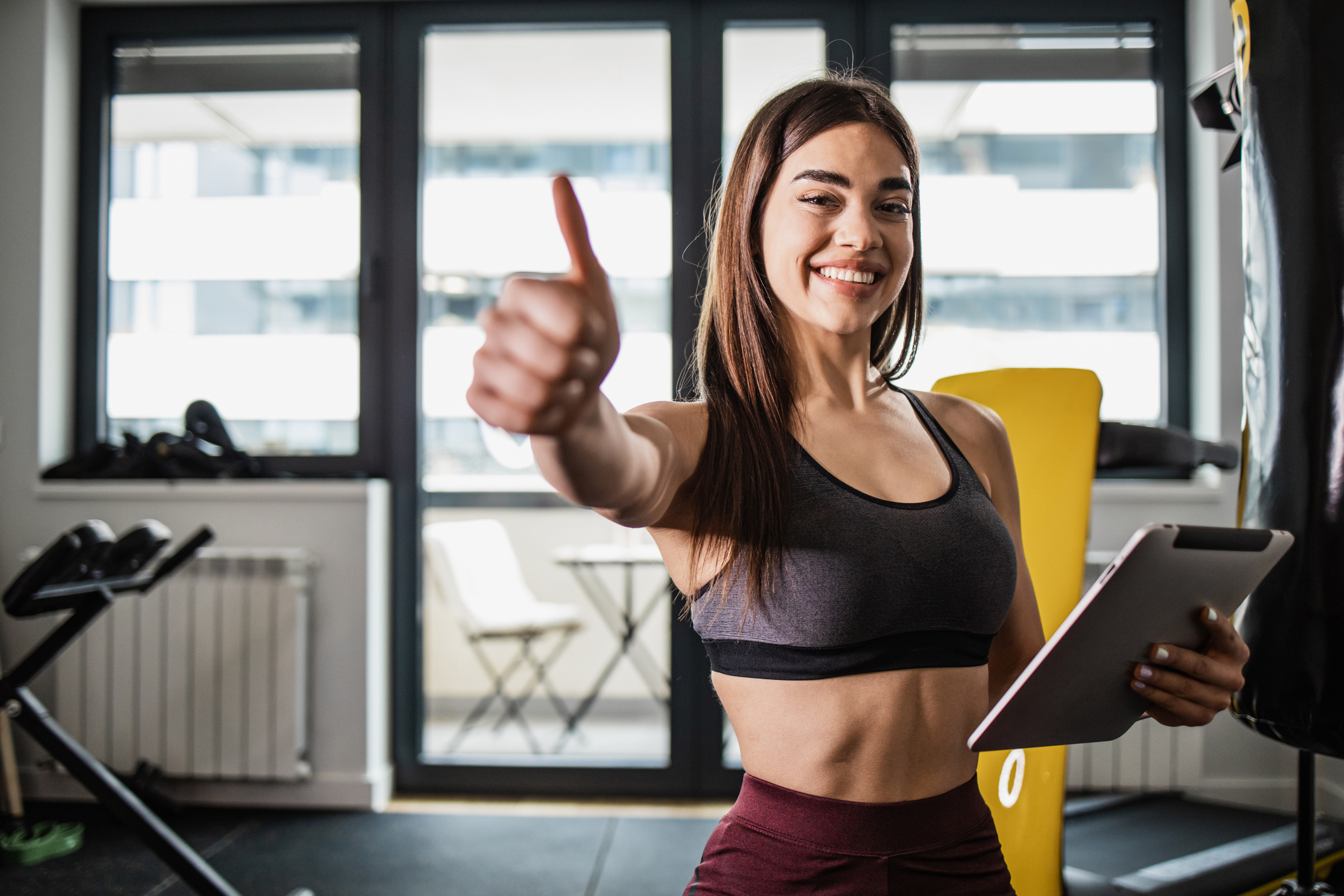 Woman in workout clothes holding a clipboard.