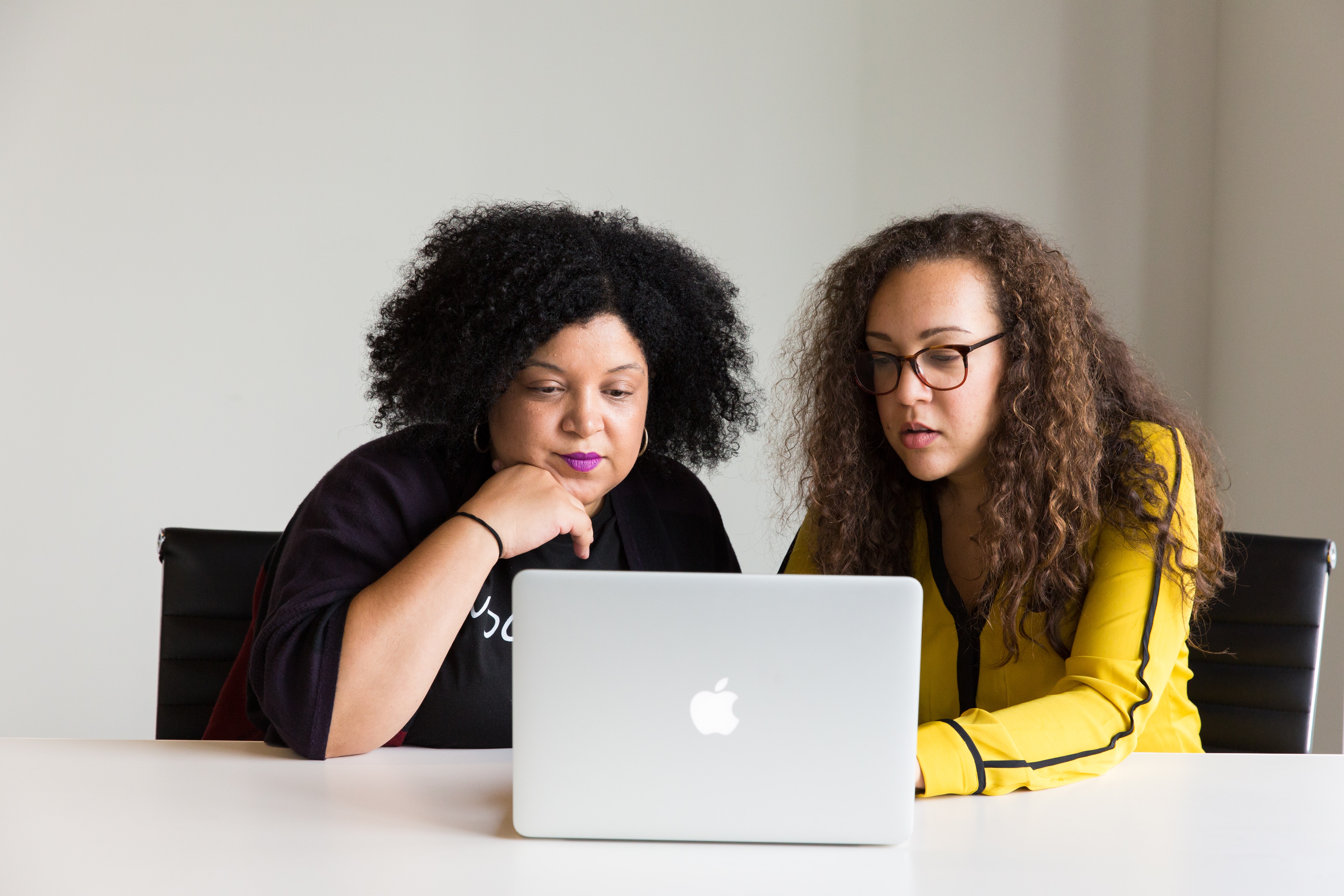 Two women working on a laptop.