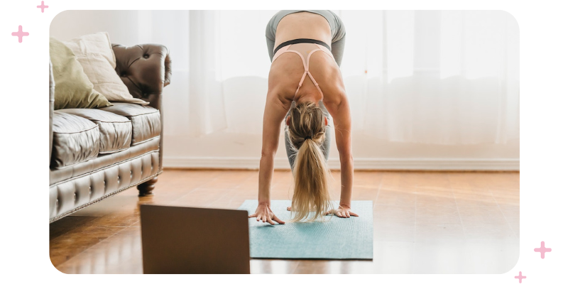 A girl doing yoga in front of a computer.