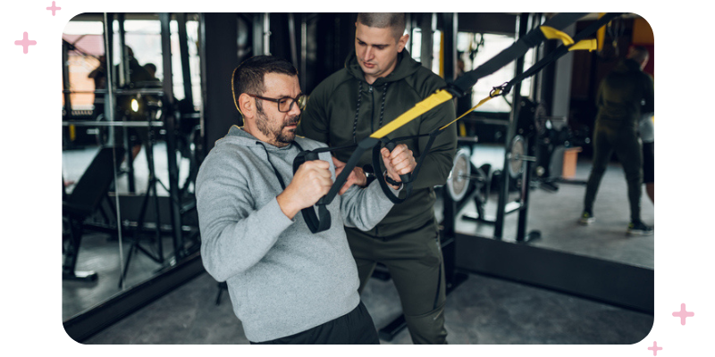 Personal trainer with a client at the gym.