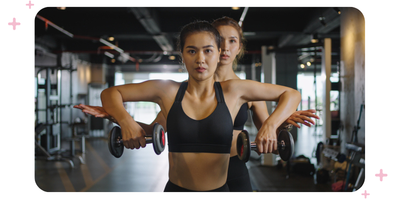 A coach teaching a client how to lift weights.